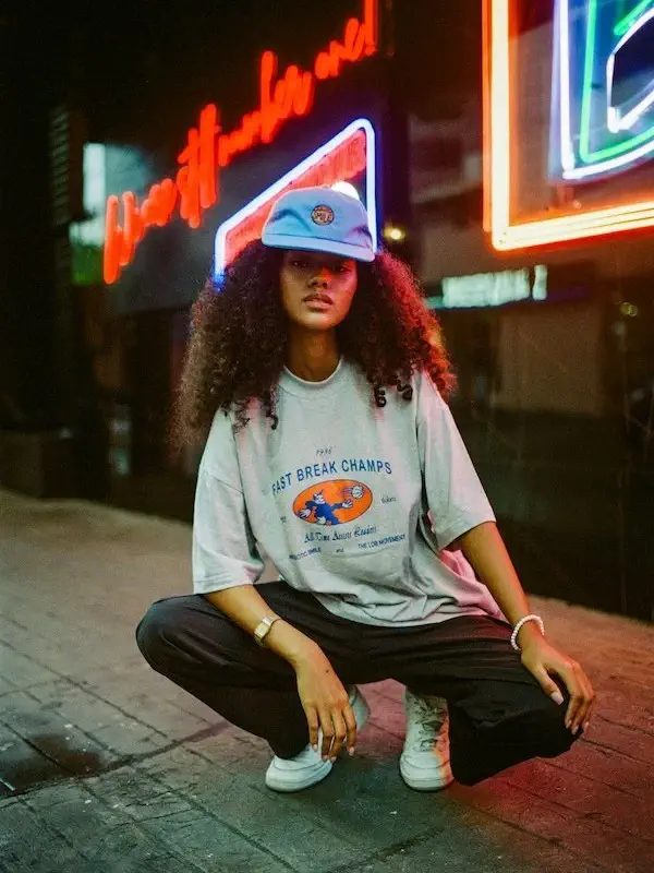 woman posing in front of neon lights showing off her style