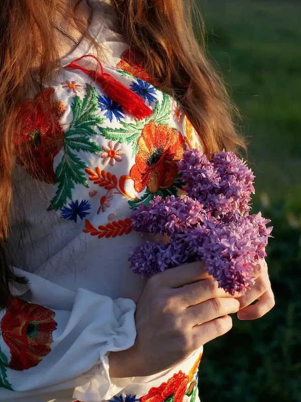 woman in colorful dress holding a bouquet of flowers