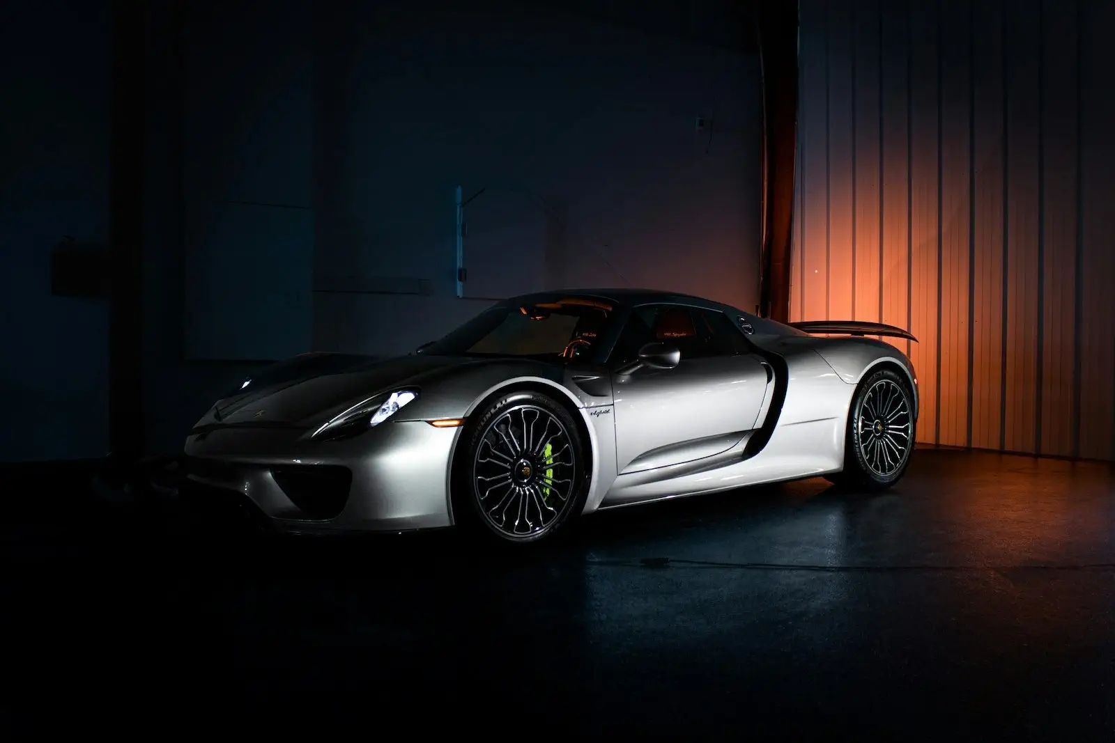 low-light side view of a silver Porsche 918 Spyder